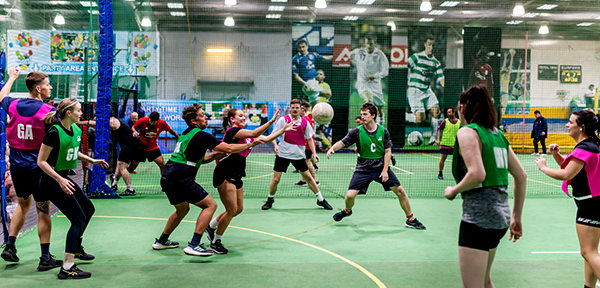 Netball players competing on an indoor court