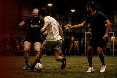 Soccer players passing the ball during an indoor game