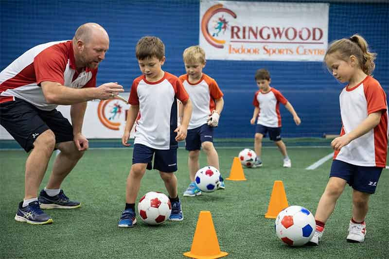 Children learning soccer with a coach